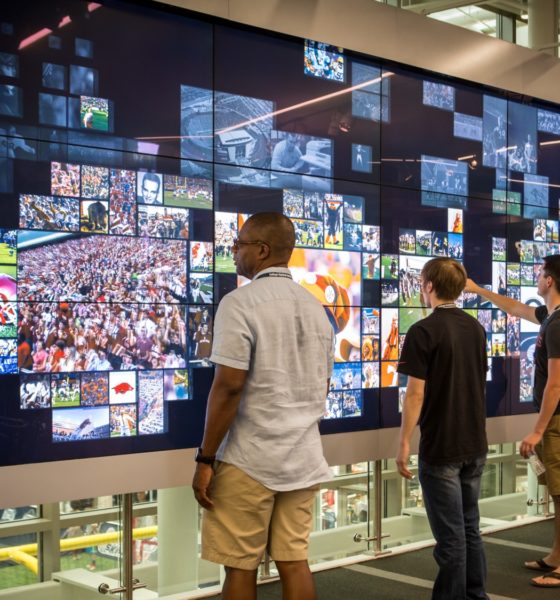 Des visiteurs interagissent avec l’écran tactile géant du College Football Hall of Fame